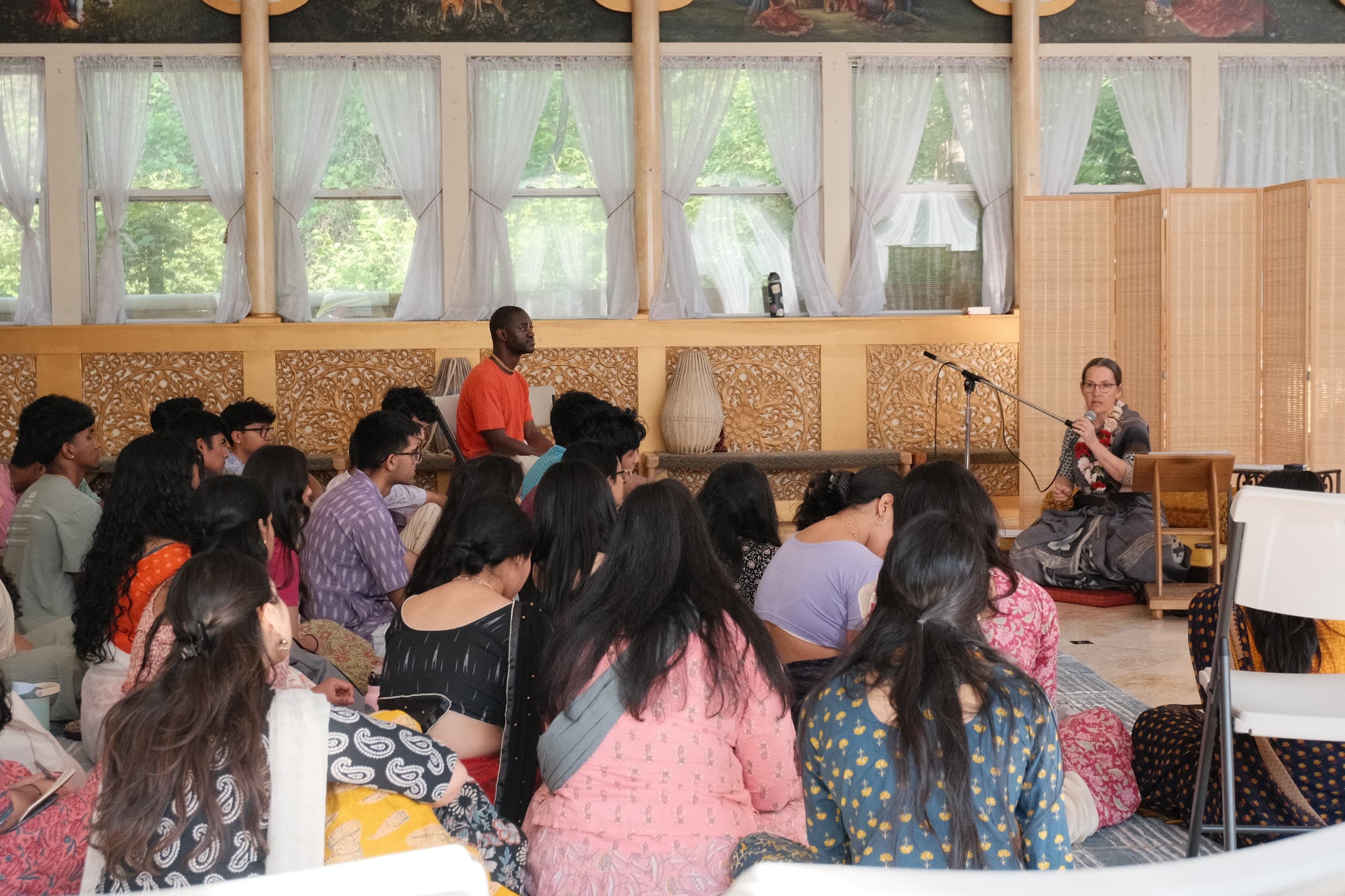 Retreat participants sitting together on the floor during a morning class